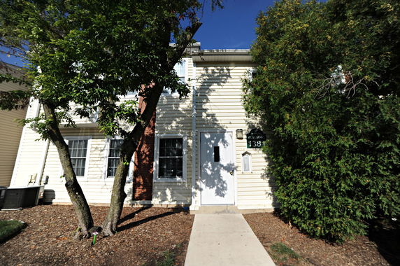 Front view of a two-story house with siding and a central entrance.