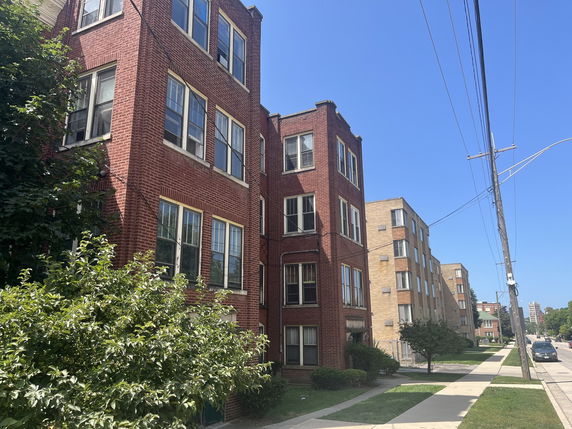 Front view of a multi-story red brick apartment building.