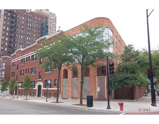Front view of a multi-story brick building on a city street corner.