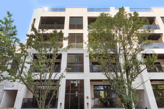 Front view of a multi-story building with large windows and glass balconies.