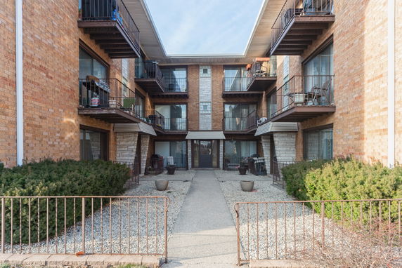 Front view of a multi-story residential building with balconies.
