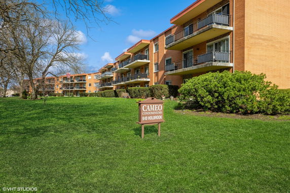 Front view of a multi-story condominium building with balconies.