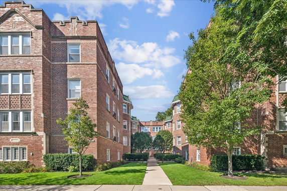 Front view of a brick multi-story apartment building.