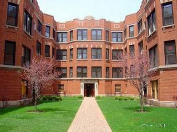 Front view of a multi-story brick building with multiple windows.