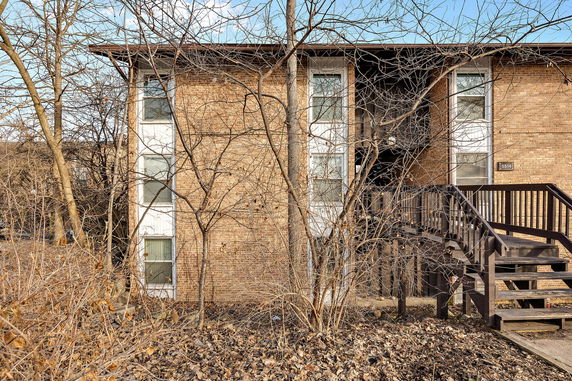 Front view of a two-story brick building with external staircase.
