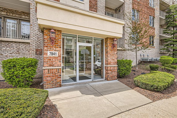 Front view of a building entrance with brick and glass elements.
