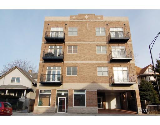 Front view of a four-story brick apartment building with balconies.