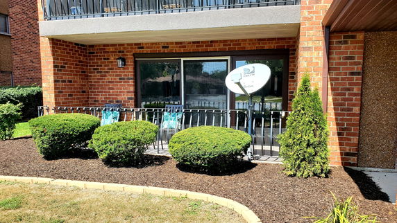Front view of a building with brick facade and balcony.