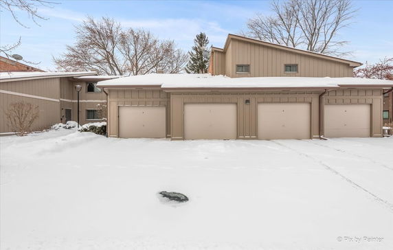 Front view of a building with multiple garage doors in a snowy environment.