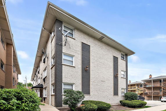 Front view of a multi-story brick apartment building.