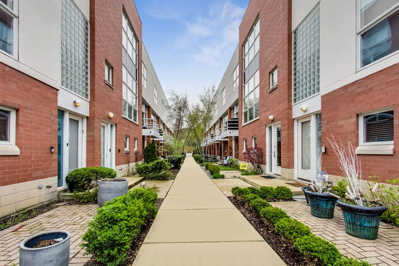 Front view of modern row houses with brick facades and large glass windows.