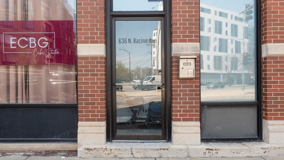 Front view of a commercial building with a glass door and brick exterior.