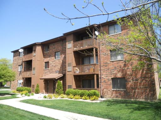 Front view of a three-story apartment building with balconies.