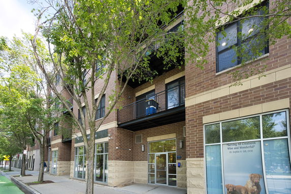 Front view of a multi-story building with brick facade and large windows.