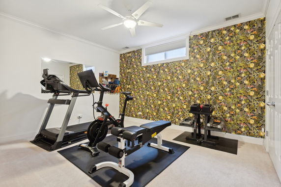 Home gym with exercise equipment including a treadmill and weights.