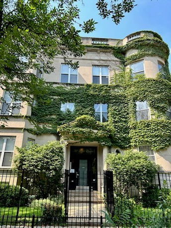 Front view of a multi-story building with ivy-covered facade.
