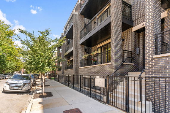 Front view of a multi-story brick building with balconies.