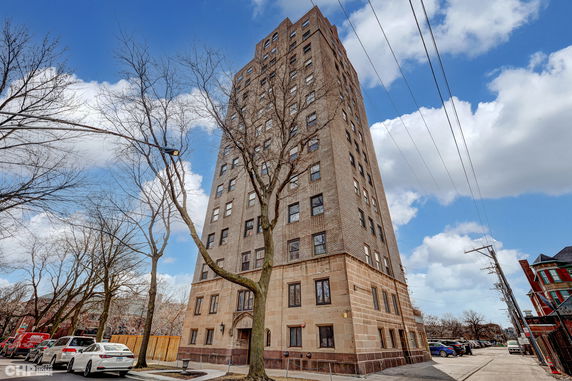 Front view of a tall brick apartment building.