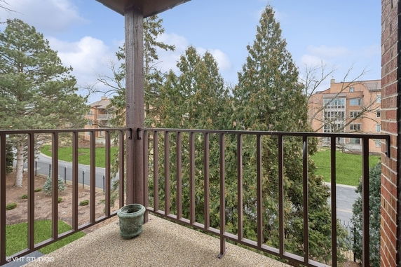 View from a balcony overlooking trees and residential buildings.