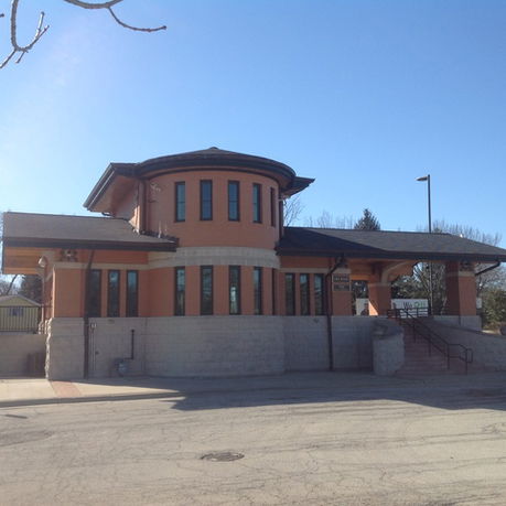 Front view of a building with a unique circular section and multiple windows.