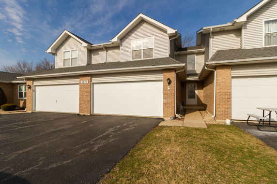 Front view of a two-story townhouse with a double garage.