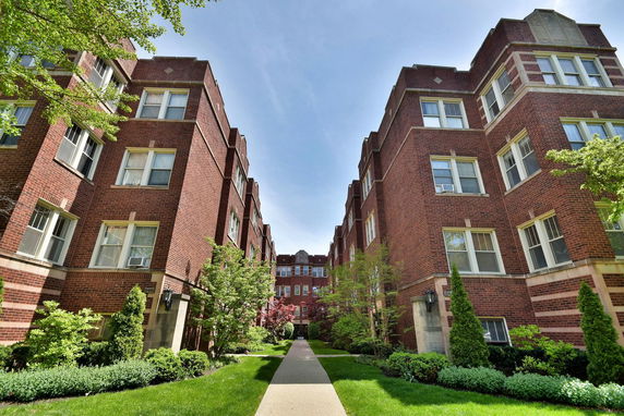 View of a brick apartment building with multiple floors.