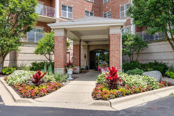 Front view of a multi-story brick building with a covered entrance.