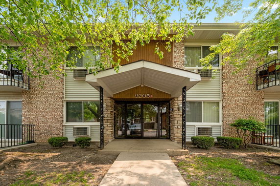 Front view of a brick residential building with a portico entrance.