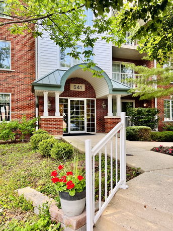 Front view of a multi-story brick building entrance with a green canopy.