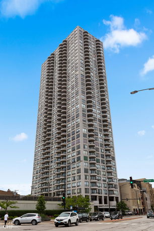 Front view of a tall apartment building with multiple balconies.