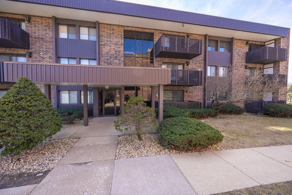 Front view of a multi-story apartment building with balconies.