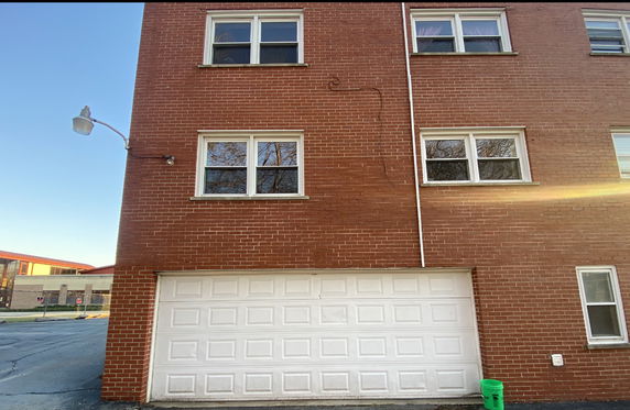 Front view of a brick building with a garage door.