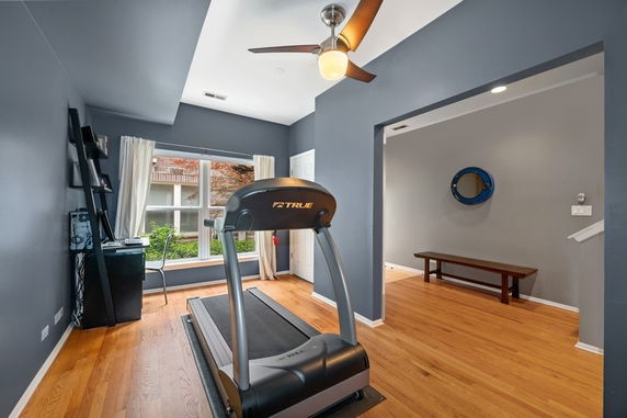 Indoor area with a treadmill and wooden flooring.