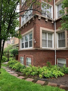 Corner view of a brick building with multiple windows and decorative stone accents.