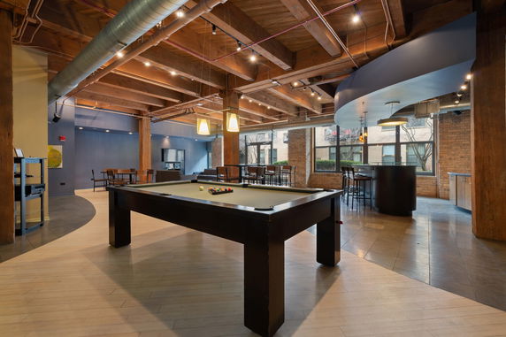 Interior view of a recreational area with a pool table and seating.