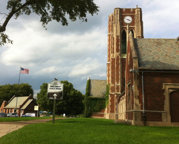 Front view of a brick building with a clock tower.
