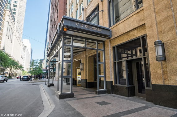 Front view of a high-rise building entrance with a modern glass and stone facade.