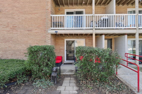 Front view of a two-story house with a small patio and balcony.