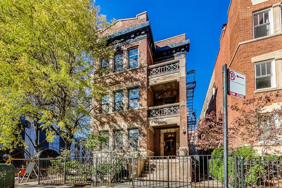 Front view of a multi-story brick building with balconies.