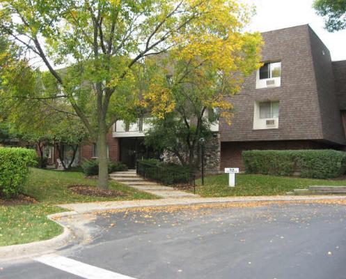 Front view of a multi-story building with brown exterior and large windows.