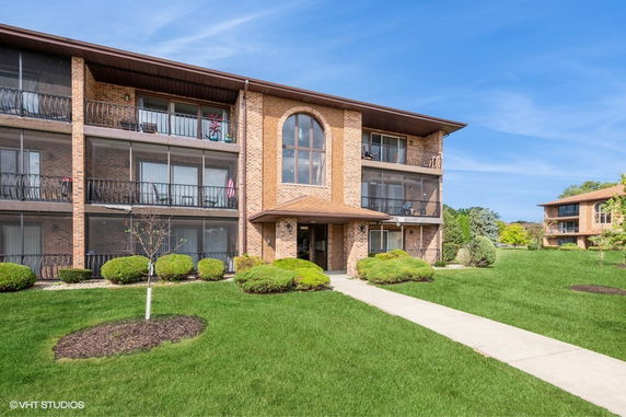 Front view of a three-story apartment building with brick construction and balconies.