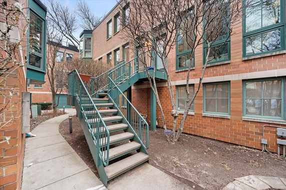 Front view of a multi-story brick building with external staircase.