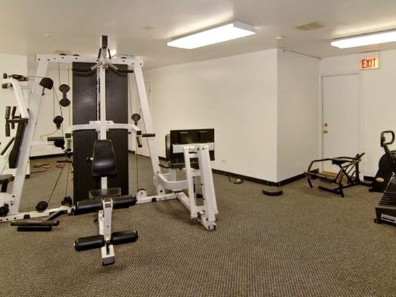 Indoor gym area with exercise equipment and machines.