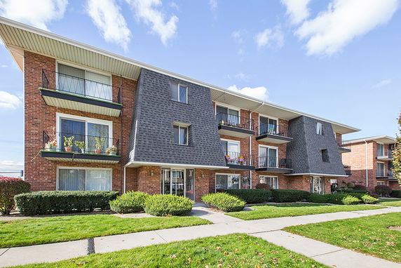 Front view of a three-story residential building with balconies.