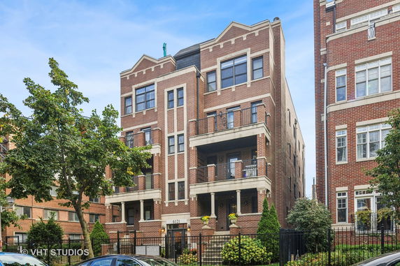 Front view of a brick multi-story apartment building.