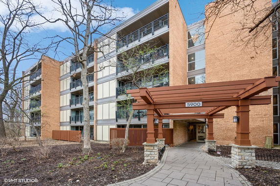 Front view of a multi-story residential building with a covered entrance.