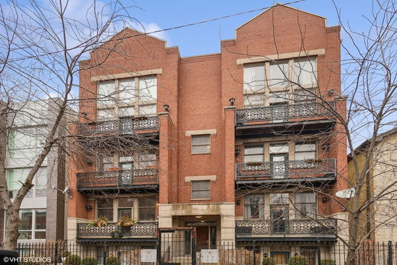 Front view of a multi-story brick building with balconies.