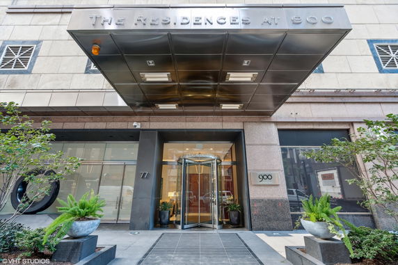 Front view of a building entrance with a revolving door and canopy.