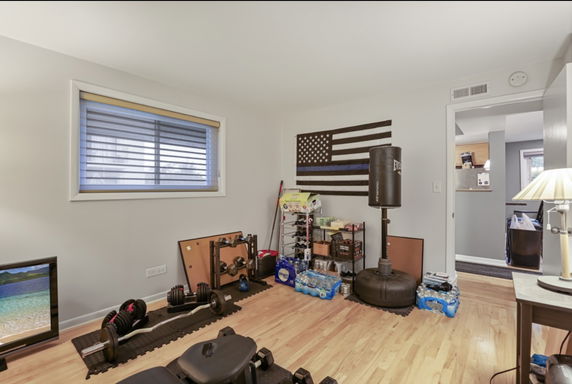 Room with gym equipment and an American flag on the wall.