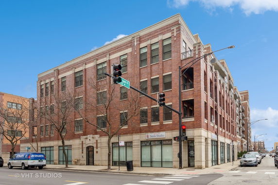 Front view of a multi-story brick building at a street corner.